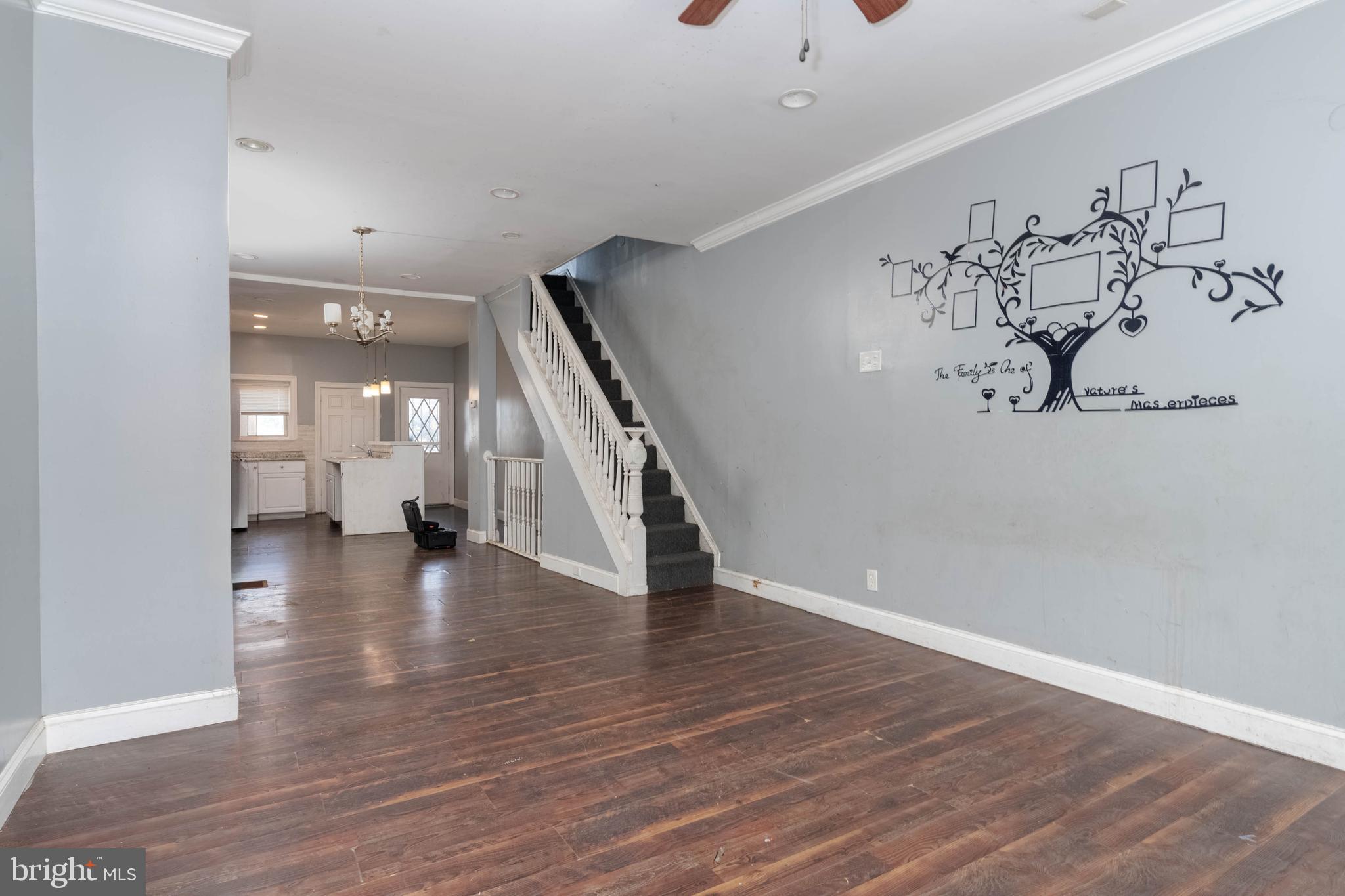 2216 West Fayette Street Baltimore, MD 21223 - Photo 6 of 36 an empty room with wooden floor and stairs
