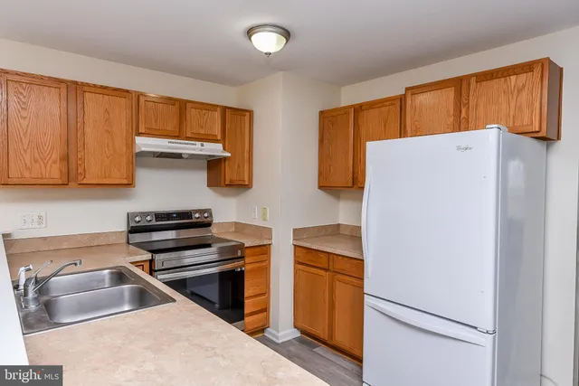 a kitchen with stainless steel appliances a refrigerator sink and cabinets