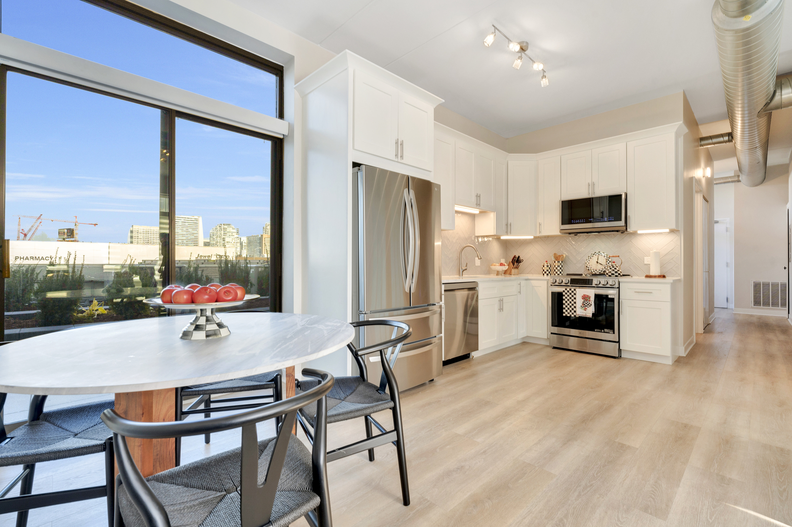 650 West Wayman Street, Unit 508 Chicago, IL 60661 - Photo 2 of 23 a kitchen with stainless steel appliances a stove a refrigerator and a dining table with wooden floor