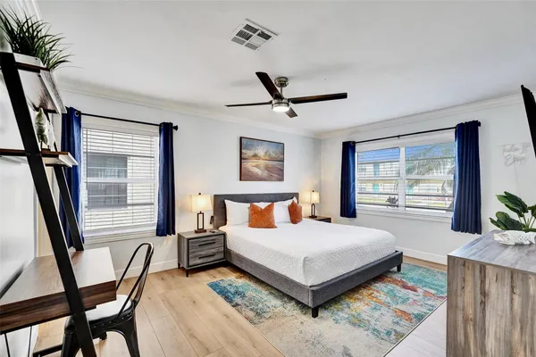 a bedroom with a bed a flat screen tv and a large window with the garden view