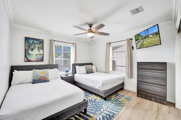 a bedroom with two beds and a painting on the wall