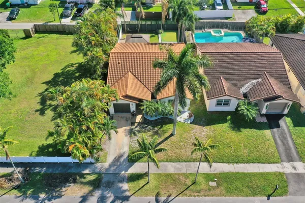 a aerial view of a house with a yard and potted plants