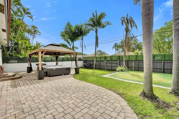 a view of a backyard with swimming pool and sitting area