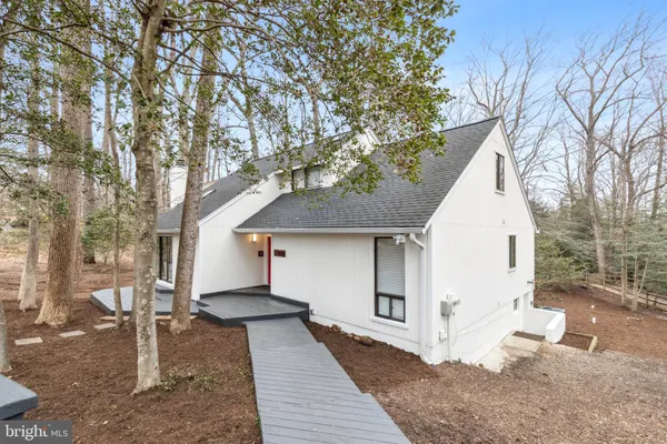 a white house that has tree in front of it