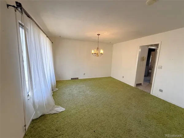 an empty room with a fireplace and cabinet