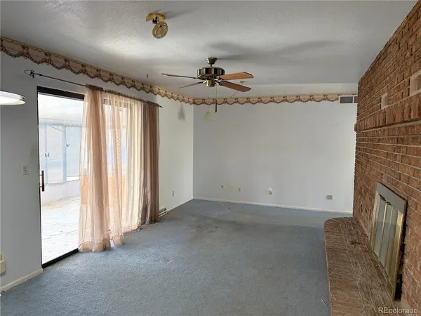 en empty room with windows and ceiling fan