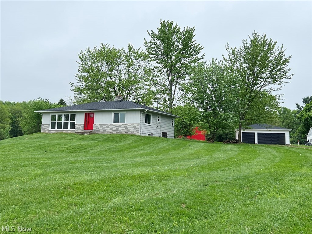 550 Johnson Road Wadsworth, OH 44281 - Photo 1 of 40 Front view of property featuring an outdoor structure, a garage, and a lawn