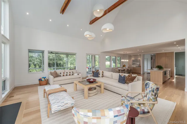 a living room with furniture fireplace and large windows