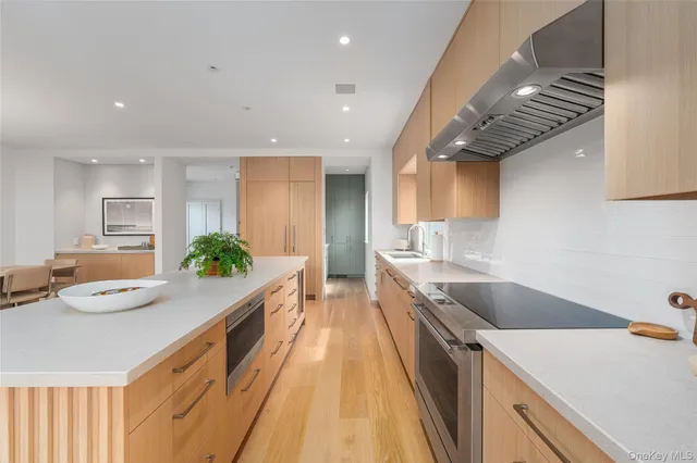 a large kitchen with stainless steel appliances a lot of counter space and a wooden floor