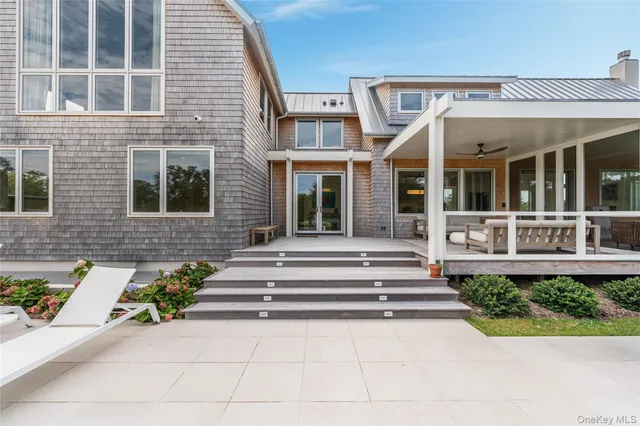 a view of a brick house with potted plants and a table and chairs