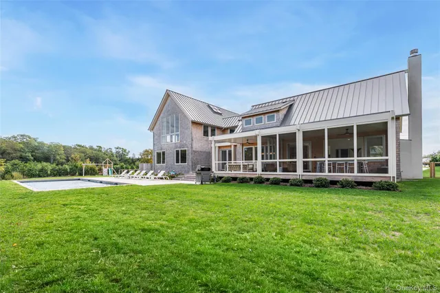 a view of a house with a big yard and large trees