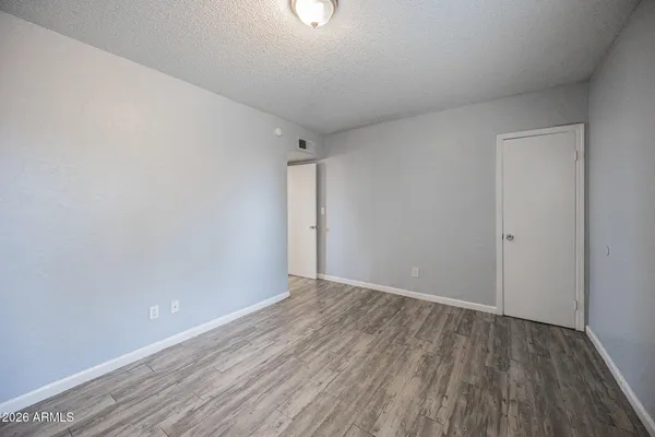 a view of an empty room with wooden floor
