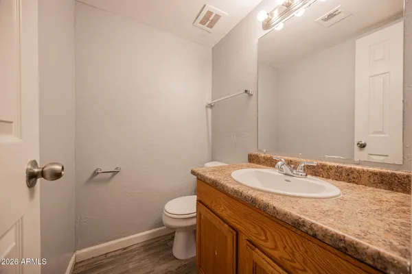 a bathroom with a granite countertop sink a toilet and a mirror