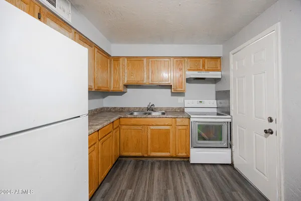 a kitchen with granite countertop a sink and a stove top oven