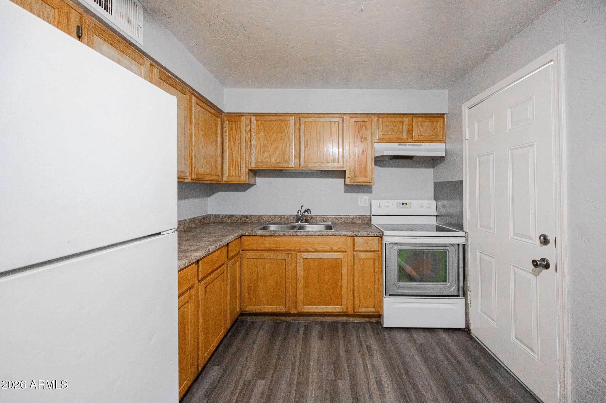 4615 North 39th Avenue, Unit 24 Phoenix, AZ 85019 - Photo 8 of 17 a kitchen with granite countertop a sink and a stove top oven