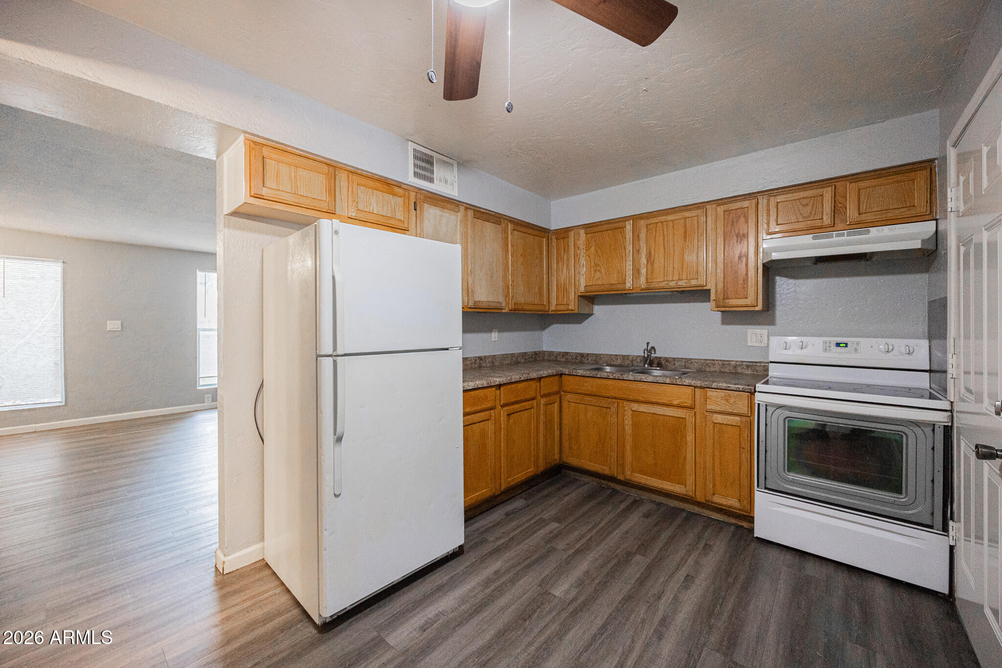 4615 North 39th Avenue, Unit 24 Phoenix, AZ 85019 - Photo 9 of 17 a kitchen with a refrigerator sink and cabinets