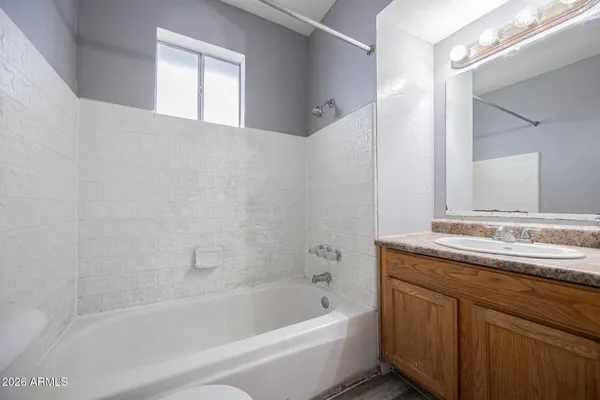 a bathroom with a tub sink and mirror