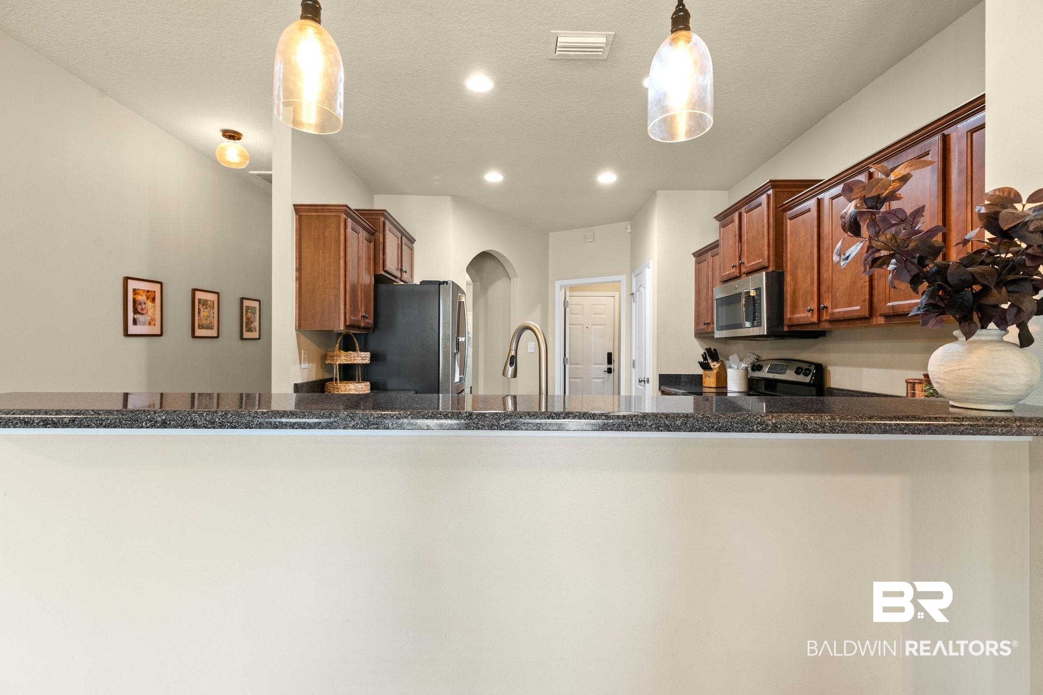 2216 Livingstone Court Mobile, AL 36695 - Photo 13 of 62 Kitchen featuring dark wood cabinetry, stainless steel appliances, and a dark stone countertop