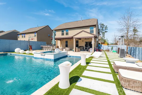 a front view of a house with swimming pool having outdoor seating