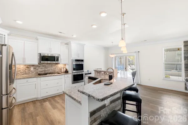 a kitchen with granite countertop a sink appliances and cabinets
