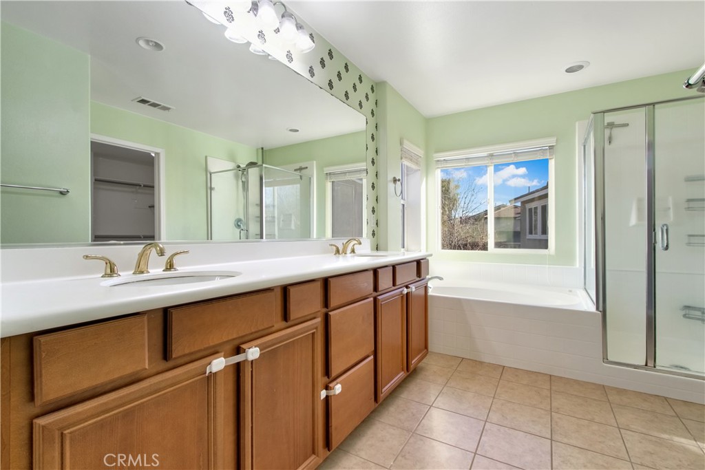 34020 Crenshaw Street Beaumont, CA 92223 - Photo 21 of 36 a spacious bathroom with a double vanity sink a mirror and a bathtub