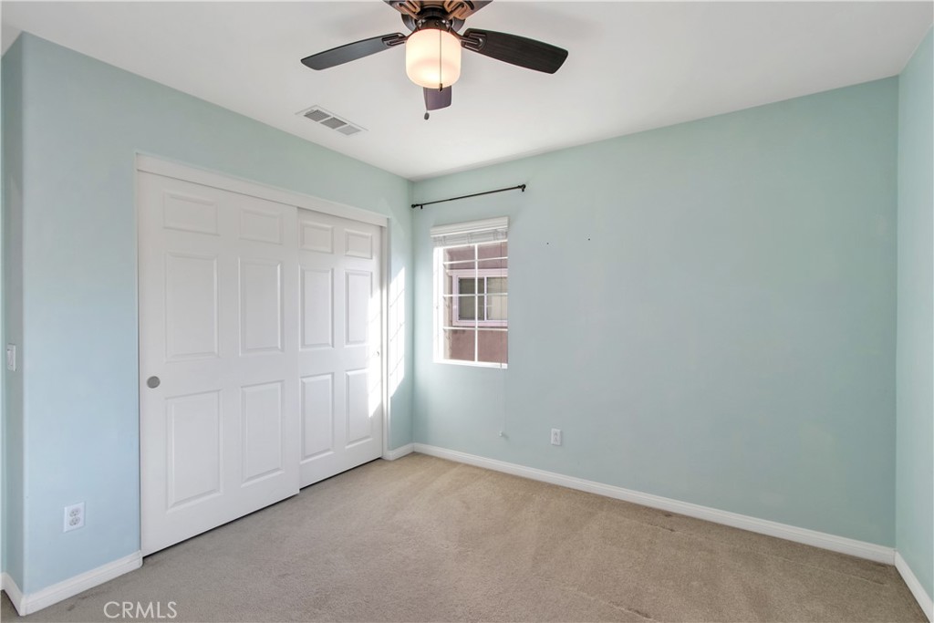34020 Crenshaw Street Beaumont, CA 92223 - Photo 28 of 36 an empty room with a chandelier fan and windows