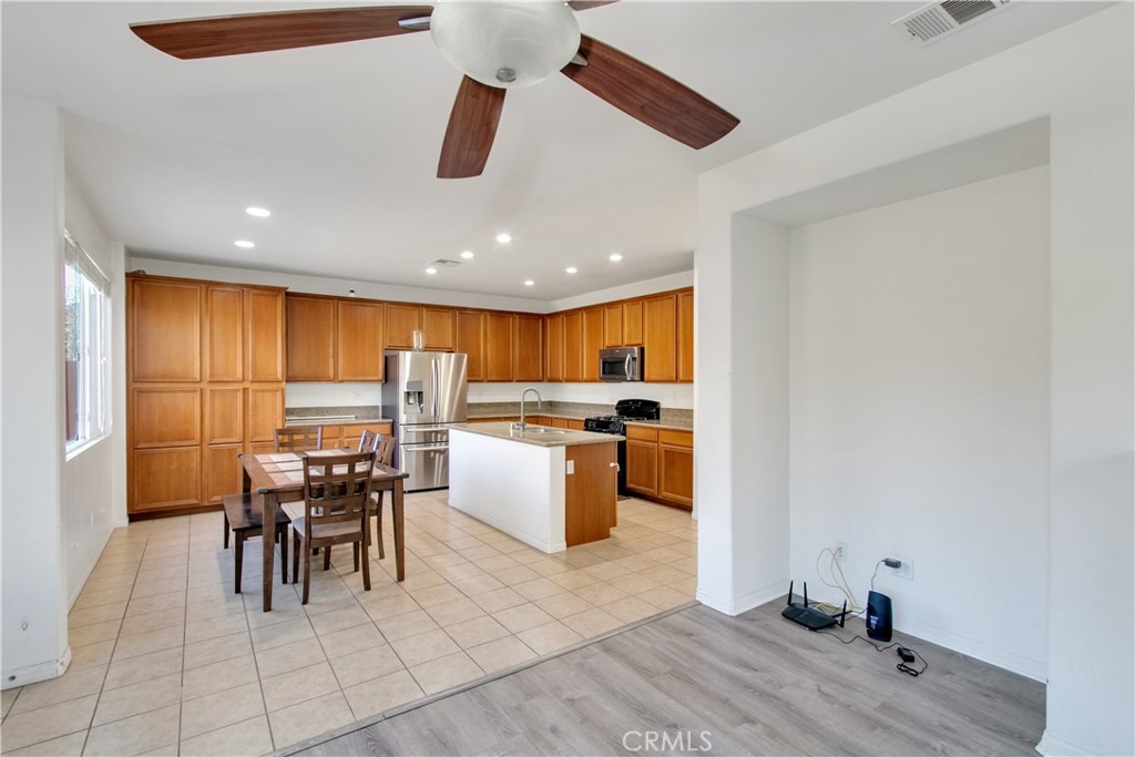 34020 Crenshaw Street Beaumont, CA 92223 - Photo 9 of 36 a kitchen with a dining table chairs and white appliances