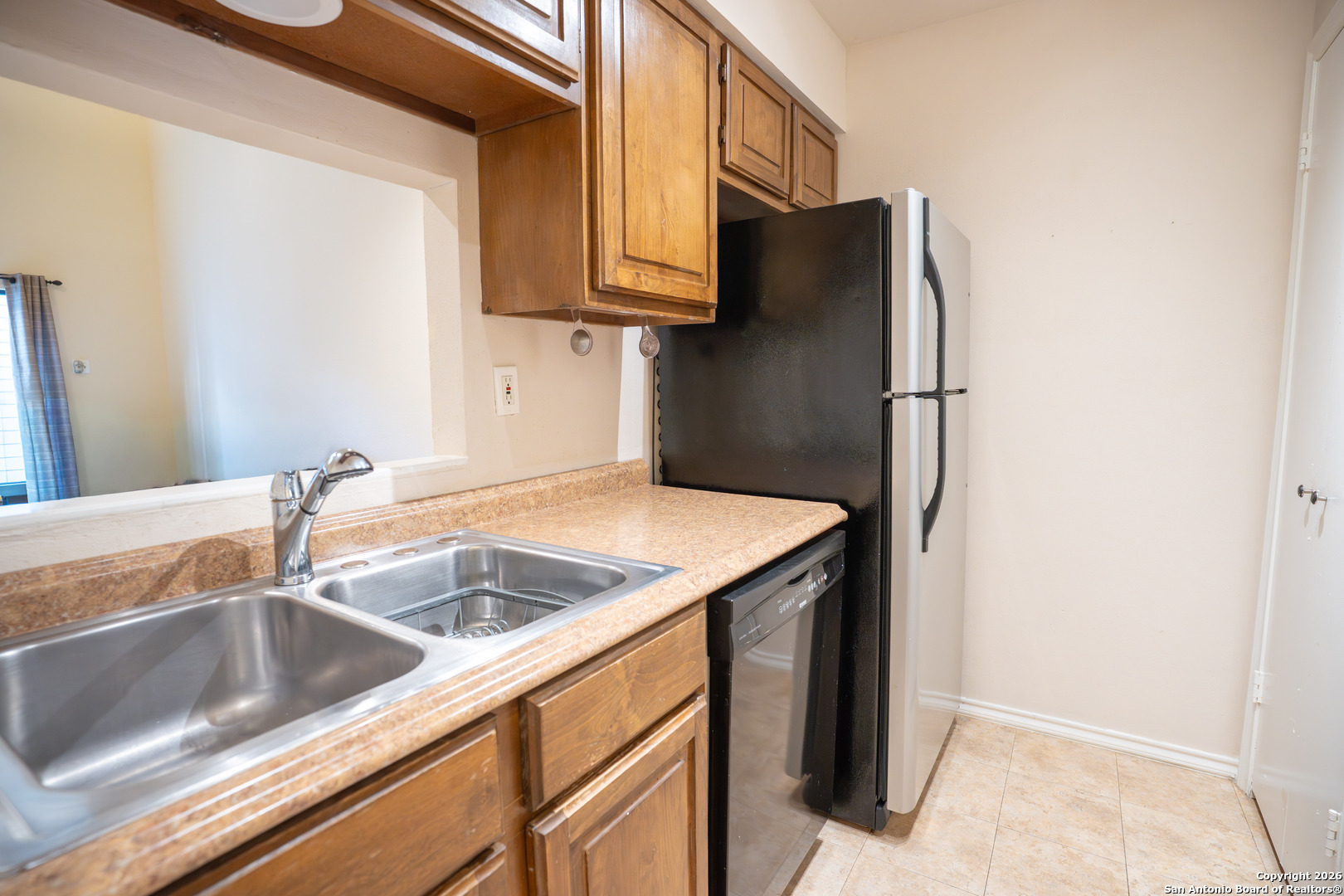 11001 Wurzbach Road, Unit 401 San Antonio, TX 78230 - Photo 2 of 12 a kitchen with stainless steel appliances granite countertop a sink and a refrigerator