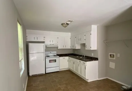 a kitchen with a refrigerator a stove a microwave and white cabinets