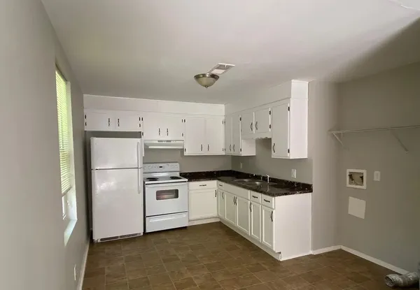 a kitchen with a refrigerator a stove a microwave and white cabinets