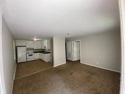 a view of a big room with kitchen and chandelier