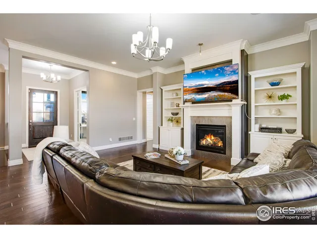 a living room with furniture a fireplace and a chandelier