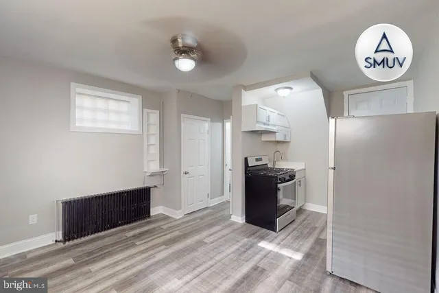 a view of a kitchen with fridge and wooden floor