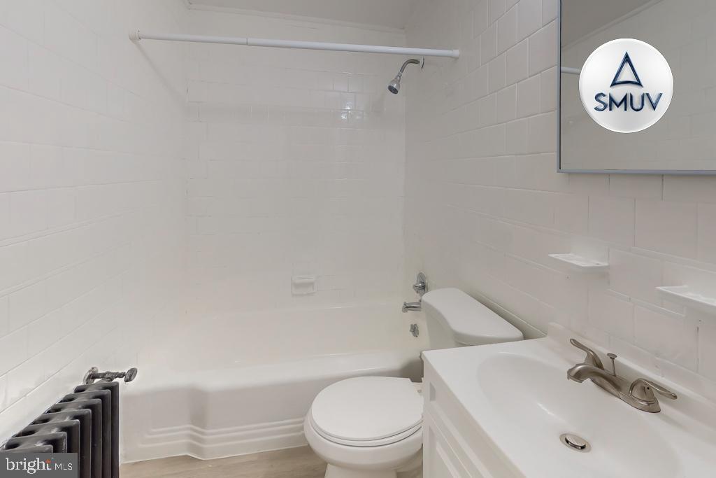 1605 Homestead Street, Unit 12 Baltimore, MD 21218 - Photo 8 of 12 a white toilet sitting next to a bathroom sink