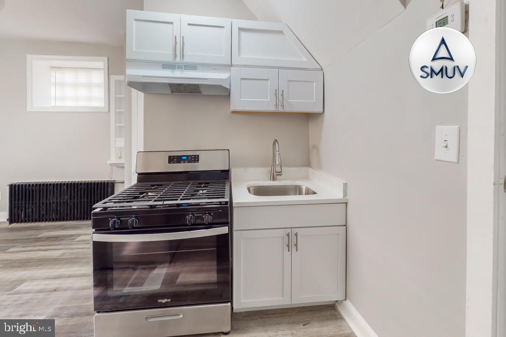 1605 Homestead Street, Unit 12 Baltimore, MD 21218 - Photo 10 of 12 a stove top oven sitting inside of a kitchen