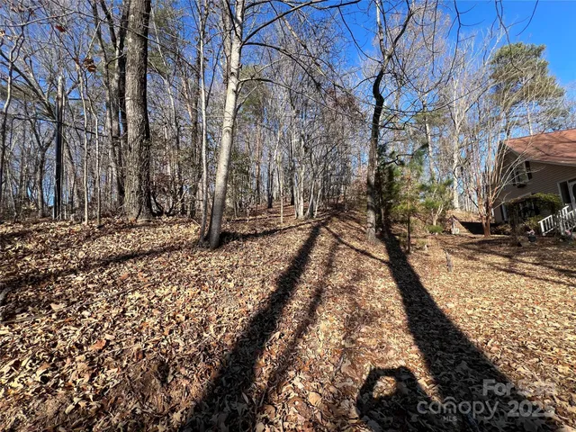 a view of an empty room with wooden floor fireplace and a window