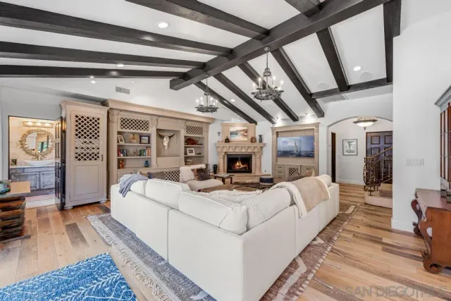 a kitchen with stainless steel appliances granite countertop a stove top oven a sink a dining table and chairs with wooden floor