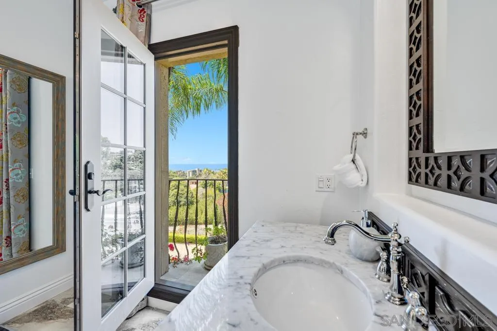 2643 Hidden Valley Road La Jolla, CA 92037 - Photo 38 of 61 a bathroom with a granite countertop sink a mirror and shower