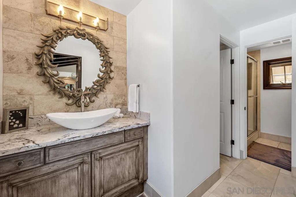 2643 Hidden Valley Road La Jolla, CA 92037 - Photo 48 of 61 a bathroom with a granite countertop sink and a mirror