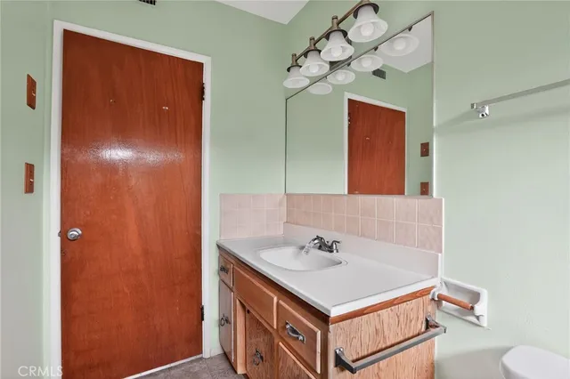 a bathroom with a sink a toilet and mirror