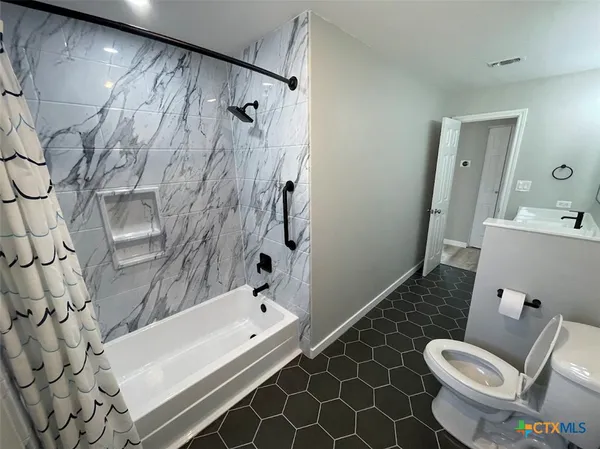 a bathroom with a double vanity sink mirror and bathtub