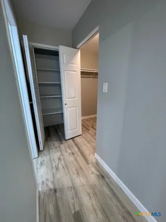 a view of empty room with kitchen and window