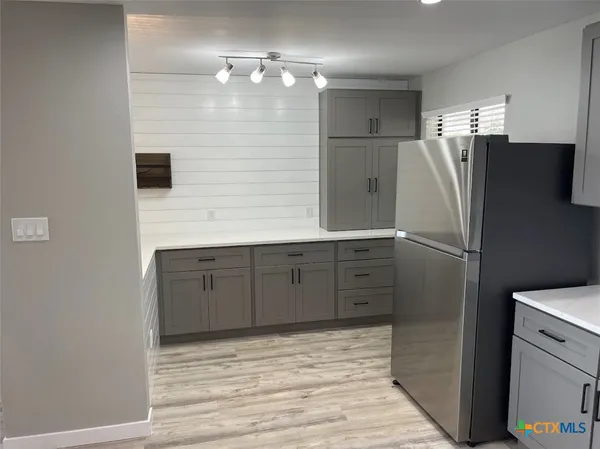 a kitchen with a table chairs a sink and cabinets