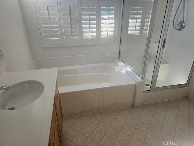 a bathroom with a tub a sink and a shower