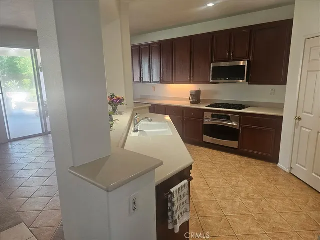 a kitchen with granite countertop a stove a sink and a refrigerator