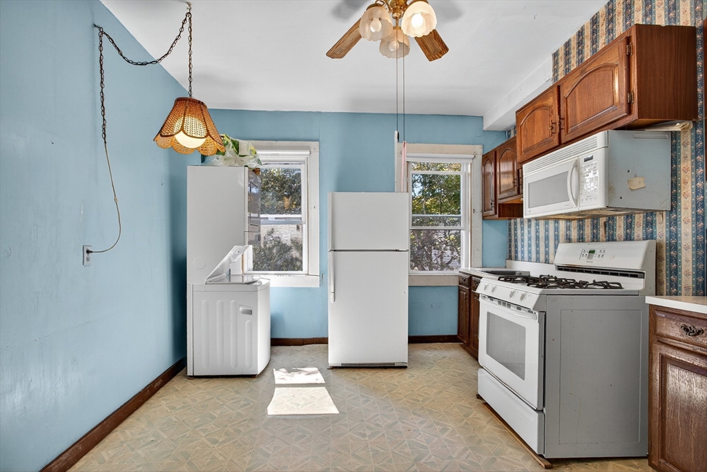 14 Wall Street Boston, MA 02129 - Photo 4 of 18 a kitchen with stainless steel appliances granite countertop a refrigerator a stove a sink and a dining table