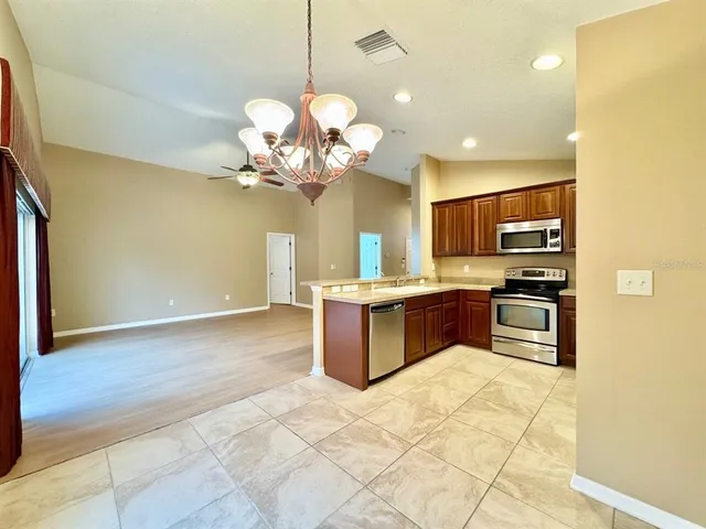 a kitchen with stainless steel appliances granite countertop a sink a stove top oven a counter space and cabinets