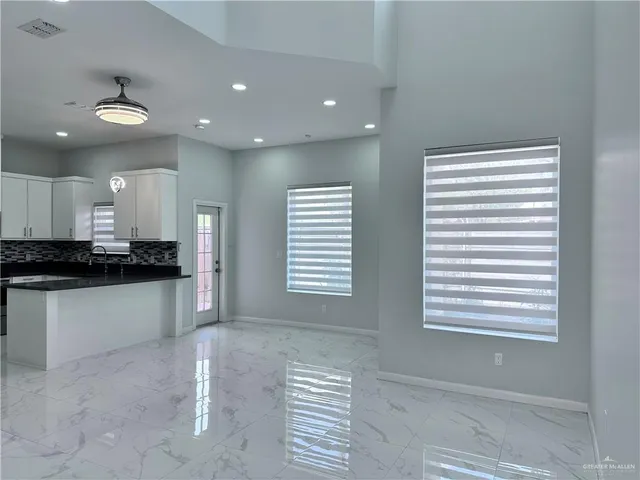 a open kitchen with kitchen island white cabinets and window