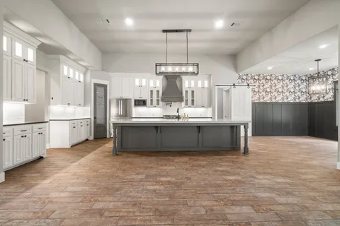a large kitchen with kitchen island a sink stainless steel appliances and cabinets