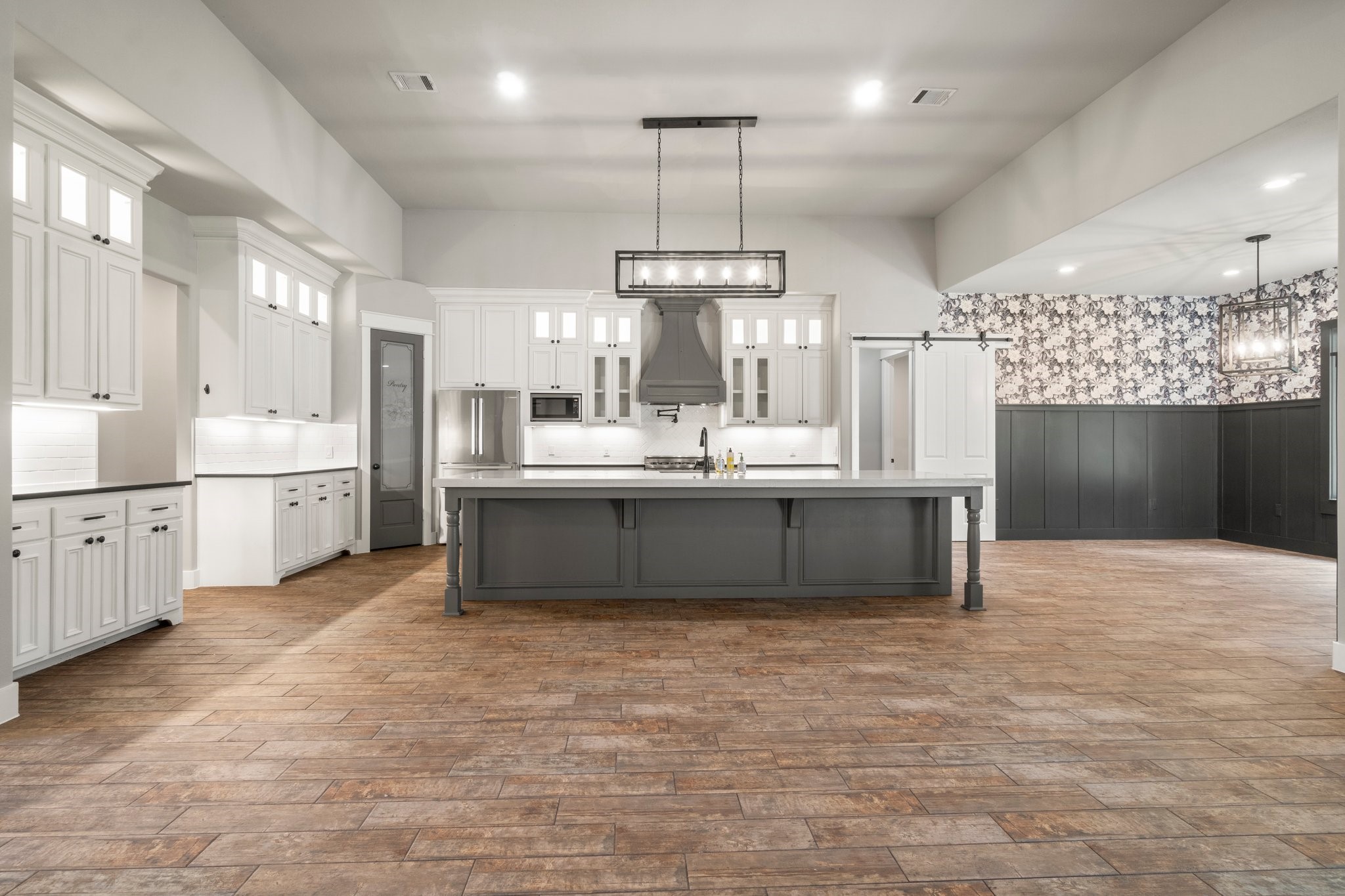 2402 Chantilly Lane Conroe, TX 77384 - Photo 1 of 49 a large kitchen with kitchen island a sink stainless steel appliances and cabinets